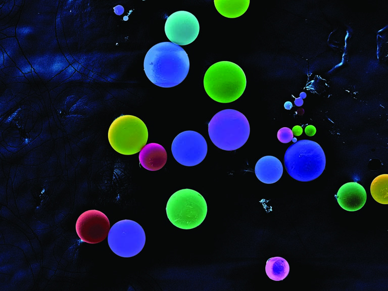 fluorescently colored spheres in shades of blue and green