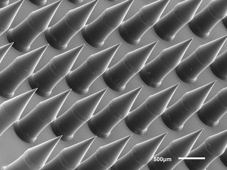 close up view of missile-shaped microneedles, grayscale with a glow around the edges