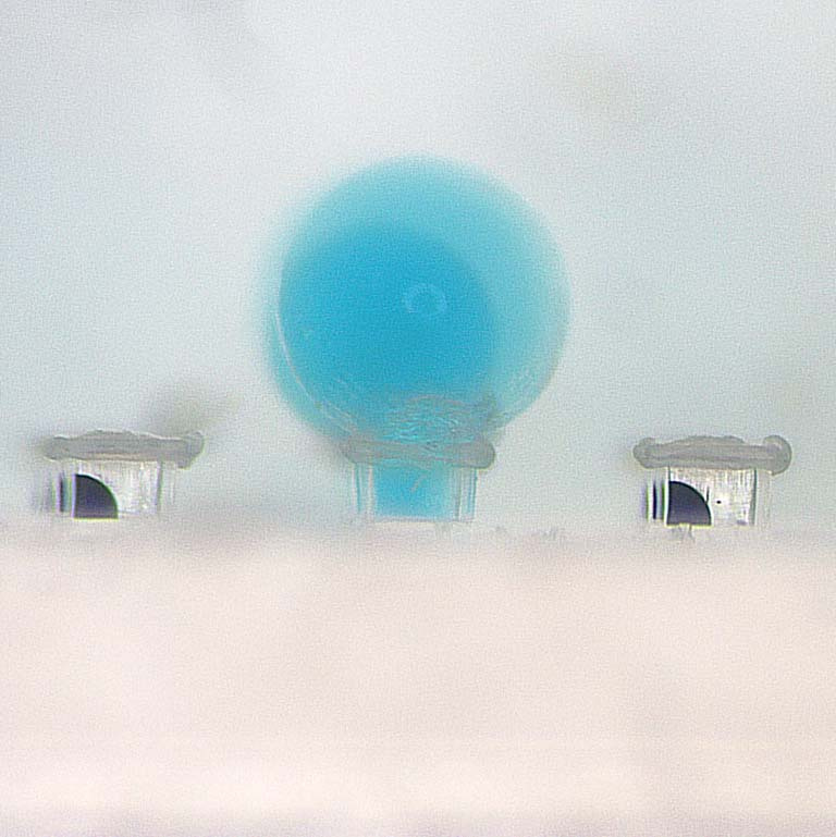 blue bubbles emerging from a clear rectangular capsule