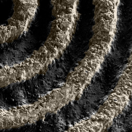 Raised, curved copper colored formations making counter clockwise rings over a dark surface