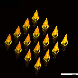translucent gold pyramids reflecting on a silicon chip, 2 millimeter scale bar in the bottom right corner