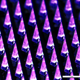 rows of pyramid-shaped microneedles, glowing magenta