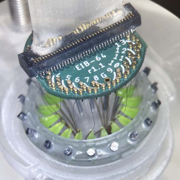 green electrodes in a cylinder attached to a round computer chip
