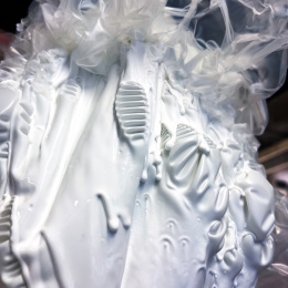 white glue drips in sheets, gauze-like at the top, pleated in the middle and sheet-like at the bottom