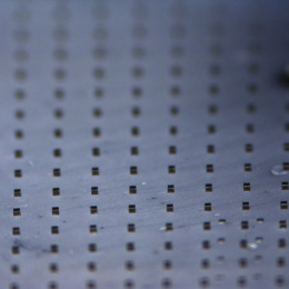 An array of polymer microparticles impregnated with gold nanorods is pictured on a standard glass microscope slide.